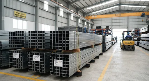 Square steel hollow structural tubes bundled securely inside clean steel warehouse, smooth cold-formed metal edges, precision fabrication stock